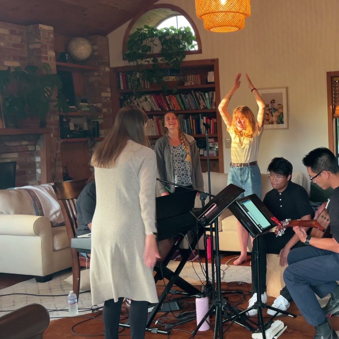 Worship night in the living room — keys, guitars, raised hands
